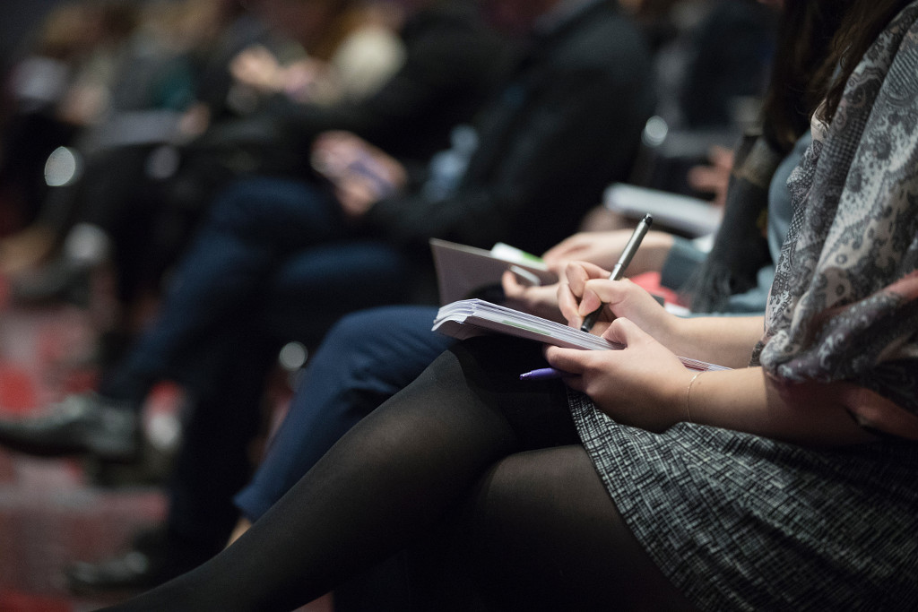 People taking notes at a conference