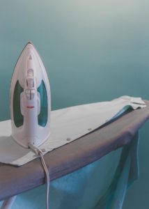 Photo of white shirt on ironing board with iron